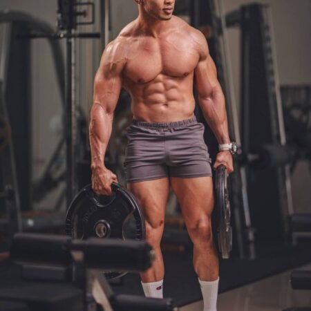 Bodybuilder walking confidently in a gym during fitness training.